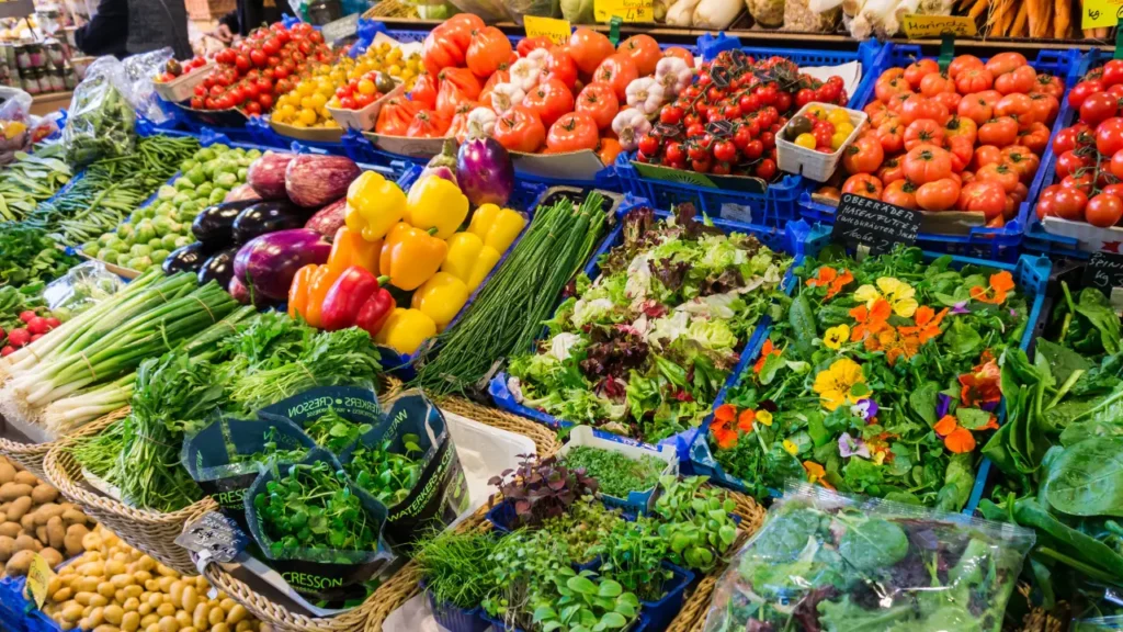 Étal coloré de fruits, légumes et herbes fraîches sur un marché de Saint-Malo illustrant les produits locaux et spécialités du terroir