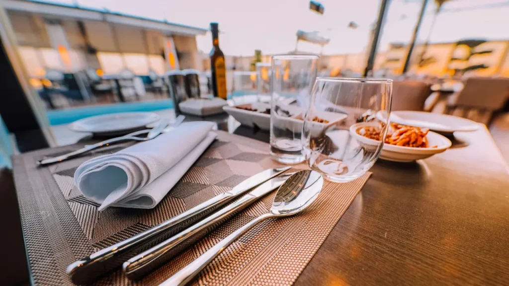 Table dressée sur une terrasse de restaurant à Saint-Malo avec couverts, verres et plats pour un repas en extérieur au bord de mer